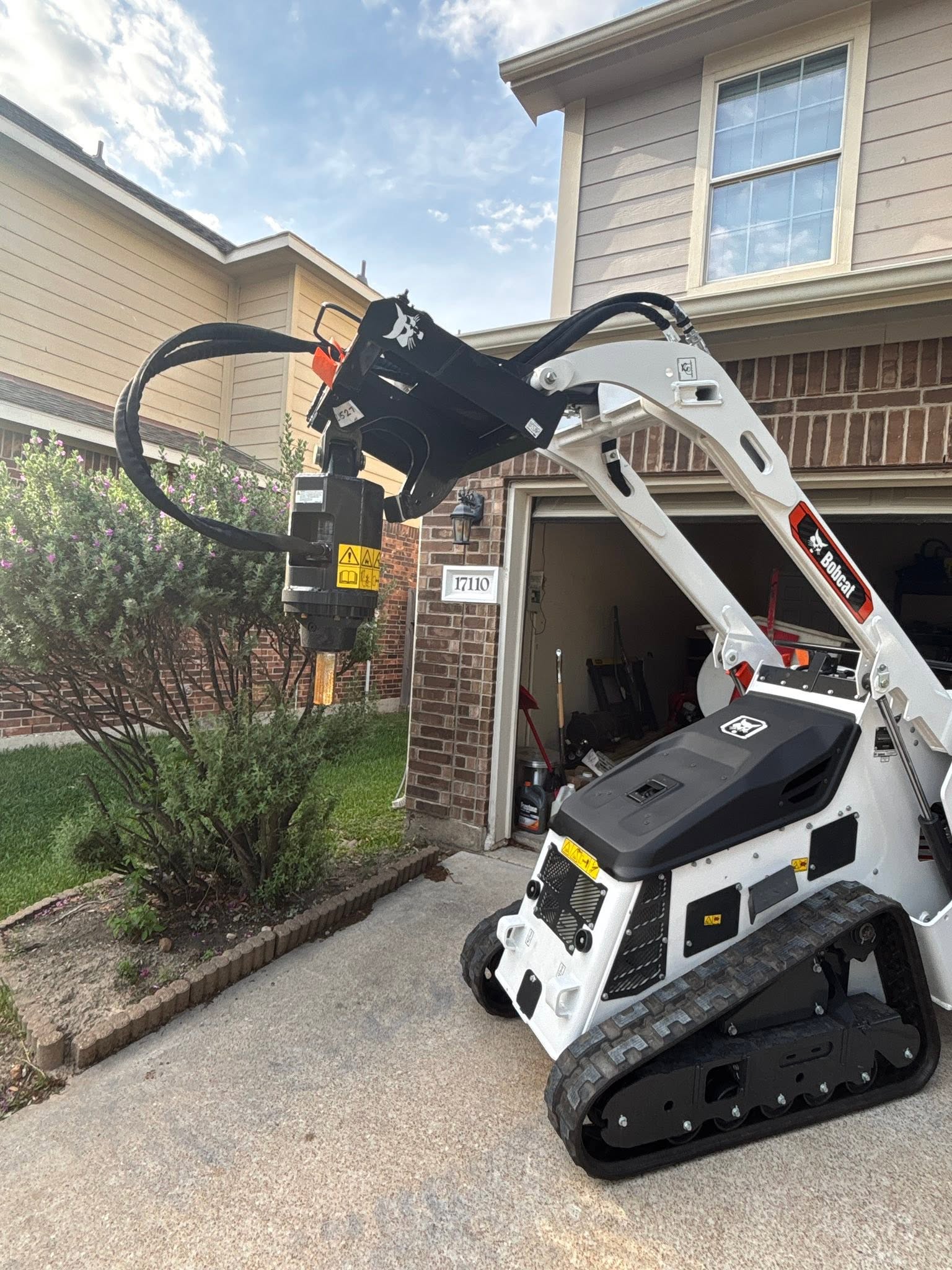 Bobcat mini track loader fitted with an auger attachment